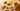 Dog surrounded by different types of dog toys including chew toys, plush toys and balls