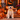 Golden Retriever puppy wearing a yellow dog collar and matching bow tie on a Halloween porch.