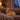Calm golden dog wearing a smart pet ID tag on a cozy couch during a thunderstorm with lightning outside the window.